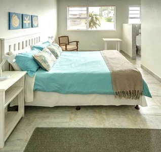 A neatly arranged bedroom with a bed, a dresser, and a small table, showcasing a simple and functional design. A neatly arranged bedroom with a bed, a dresser, and a small table, showcasing a simple and functional design.