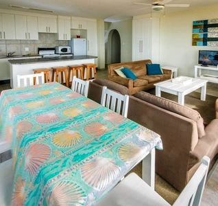 An open living room and kitchen area with a dining table, designed for comfort and social gatherings. An open living room and kitchen area with a dining table, designed for comfort and social gatherings.